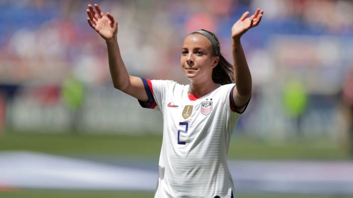 Mal Pugh in a white USWNT jersey with her hands raised